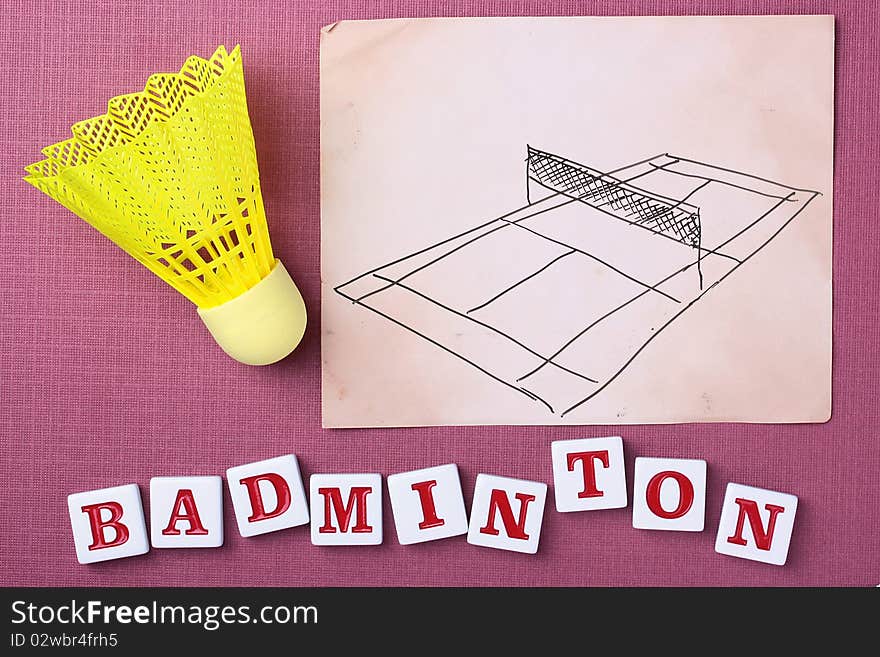 A yellow synthetic badminton shuttlecock next to a drawing of a badminton court.