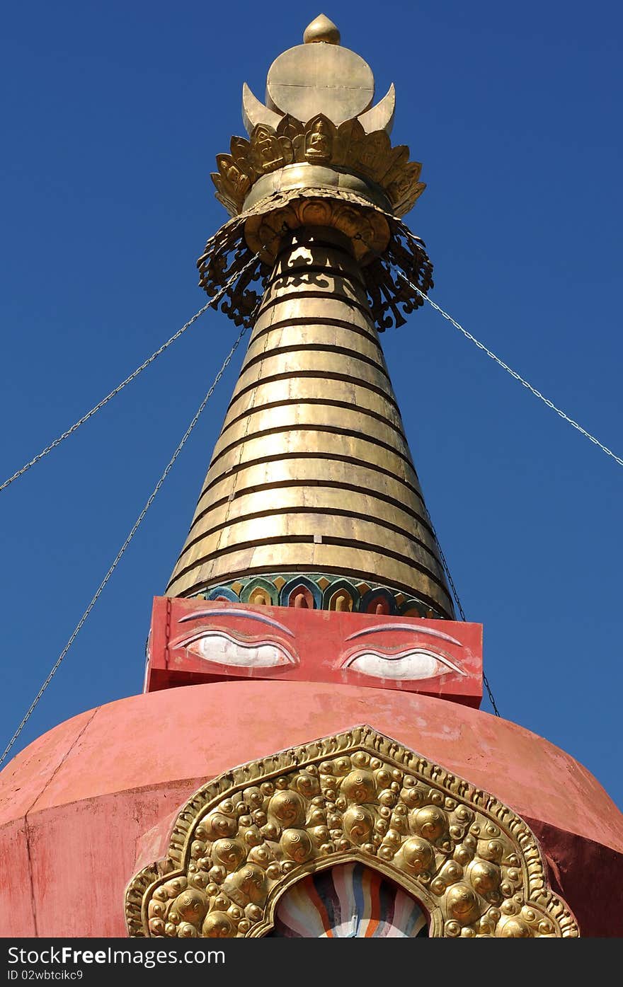 Scenery of the golden top of a red buddhist stupa in Tibet,with blue skies as backgrounds. Scenery of the golden top of a red buddhist stupa in Tibet,with blue skies as backgrounds.