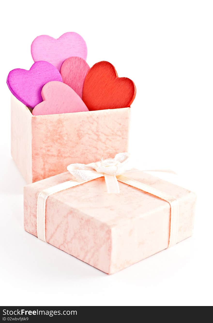 Wooden heart-shaped pink color Gift Box on the white background. Macro photo.