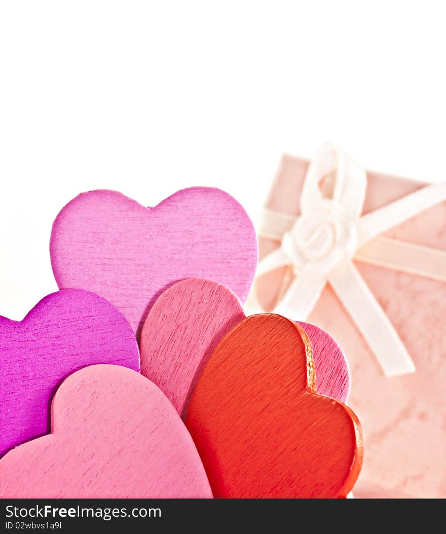 Wooden heart-shaped pink color Gift Box on the white background. Macro photo.