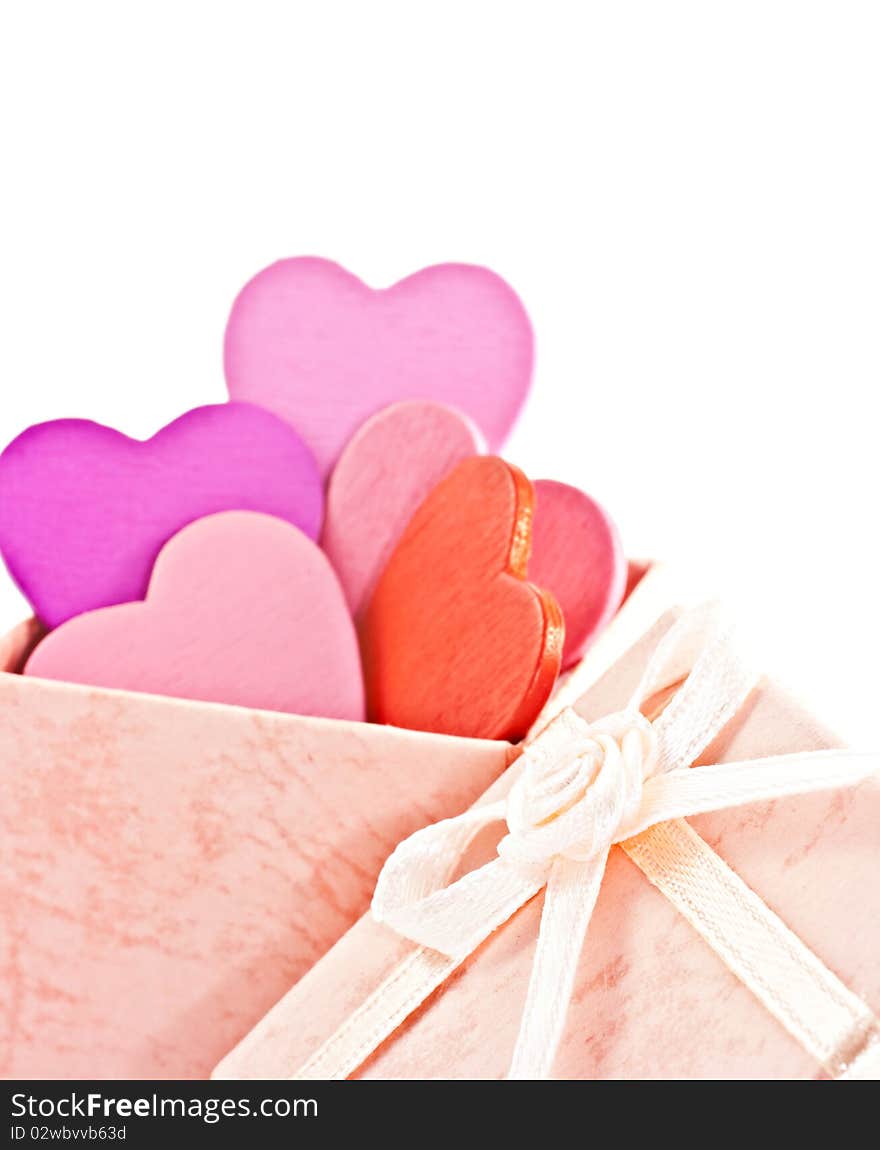 Wooden heart-shaped pink color Gift Box on the white background. Macro photo.