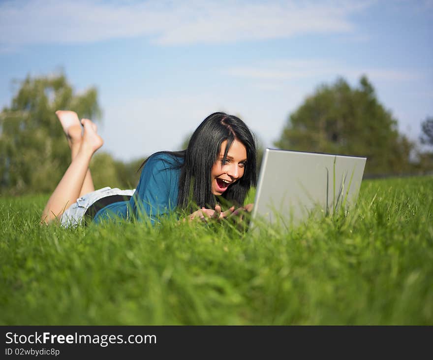 Young Girl Using Laptop In Park