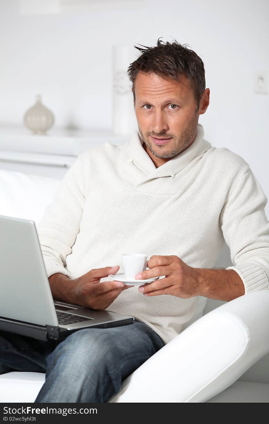 Man with laptop computer sitting in sofa. Man with laptop computer sitting in sofa