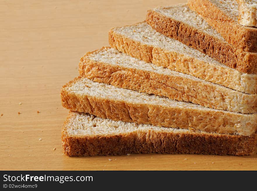 Pile up wheat bread that looks like a stair on the wooden table. Pile up wheat bread that looks like a stair on the wooden table