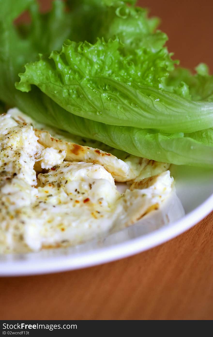 Omelette made of two eggs with milk, on a plate decorated with a leaf of lettuce. Omelette made of two eggs with milk, on a plate decorated with a leaf of lettuce