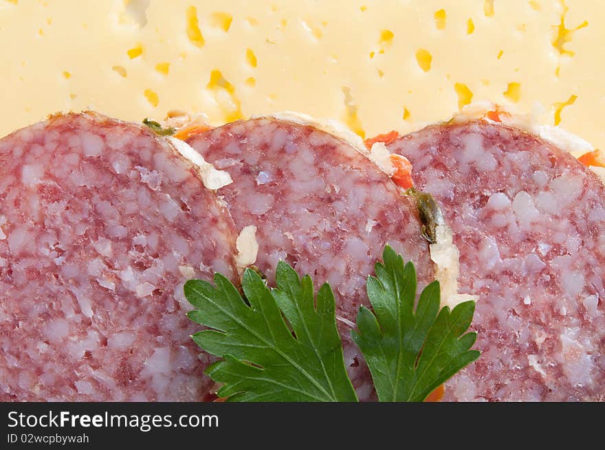 Close up of sliced salami with parsley on cheesy background. Close up of sliced salami with parsley on cheesy background