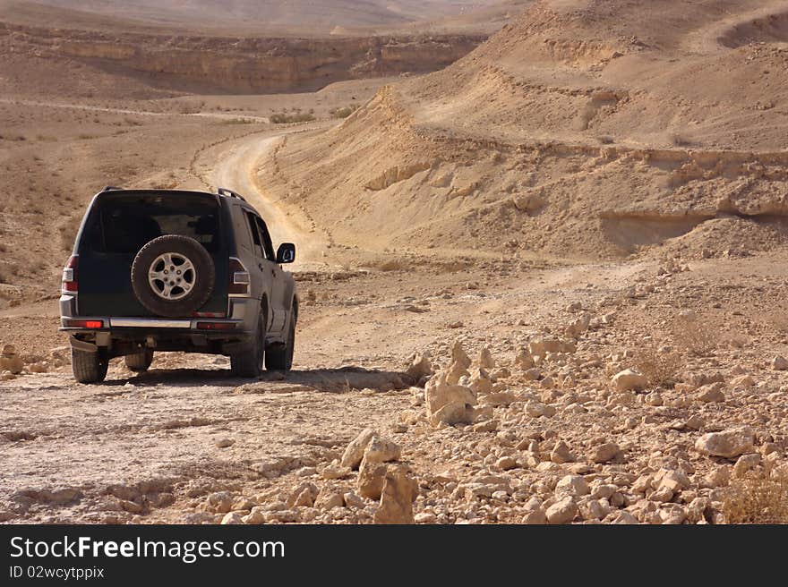 This is an image of a SUV vehicle in the Negev desert in Israel. This is an image of a SUV vehicle in the Negev desert in Israel