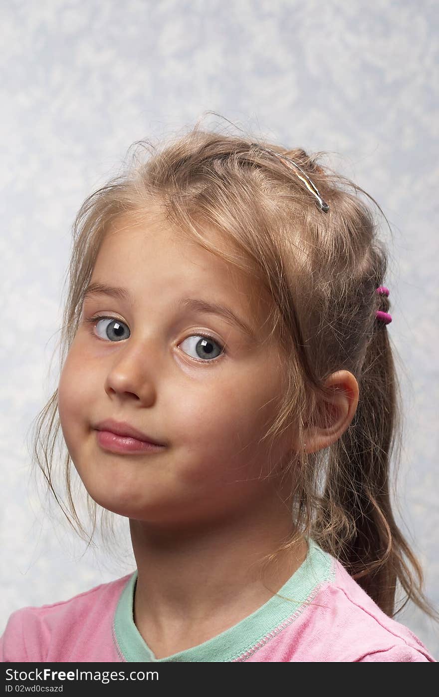 Little smiling girl portrait isolated over light blue background