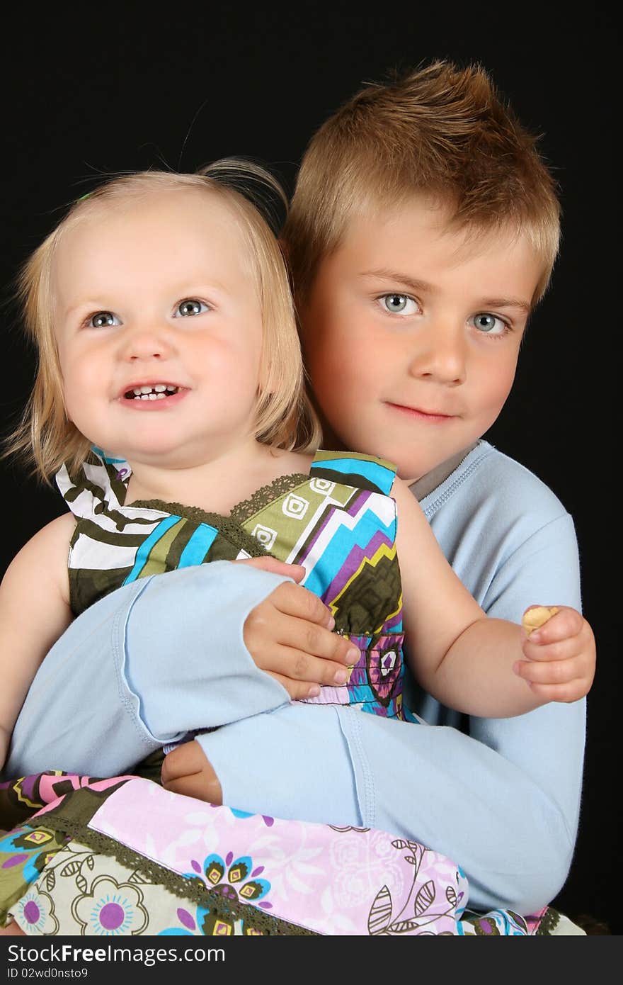 Cute brother holding his toddler sister in his arms. Cute brother holding his toddler sister in his arms