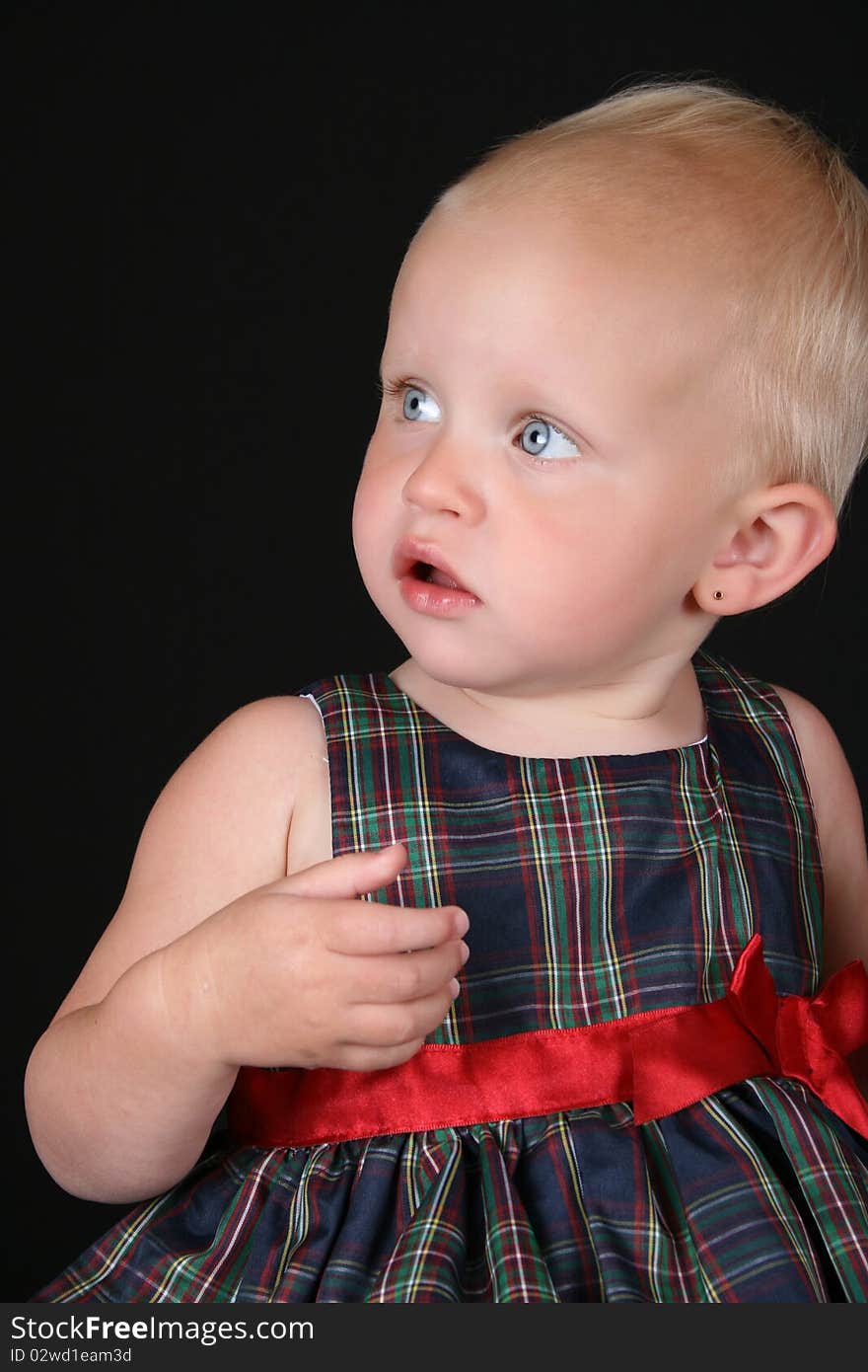 Beautiful blond toddler wearing a christmas dress