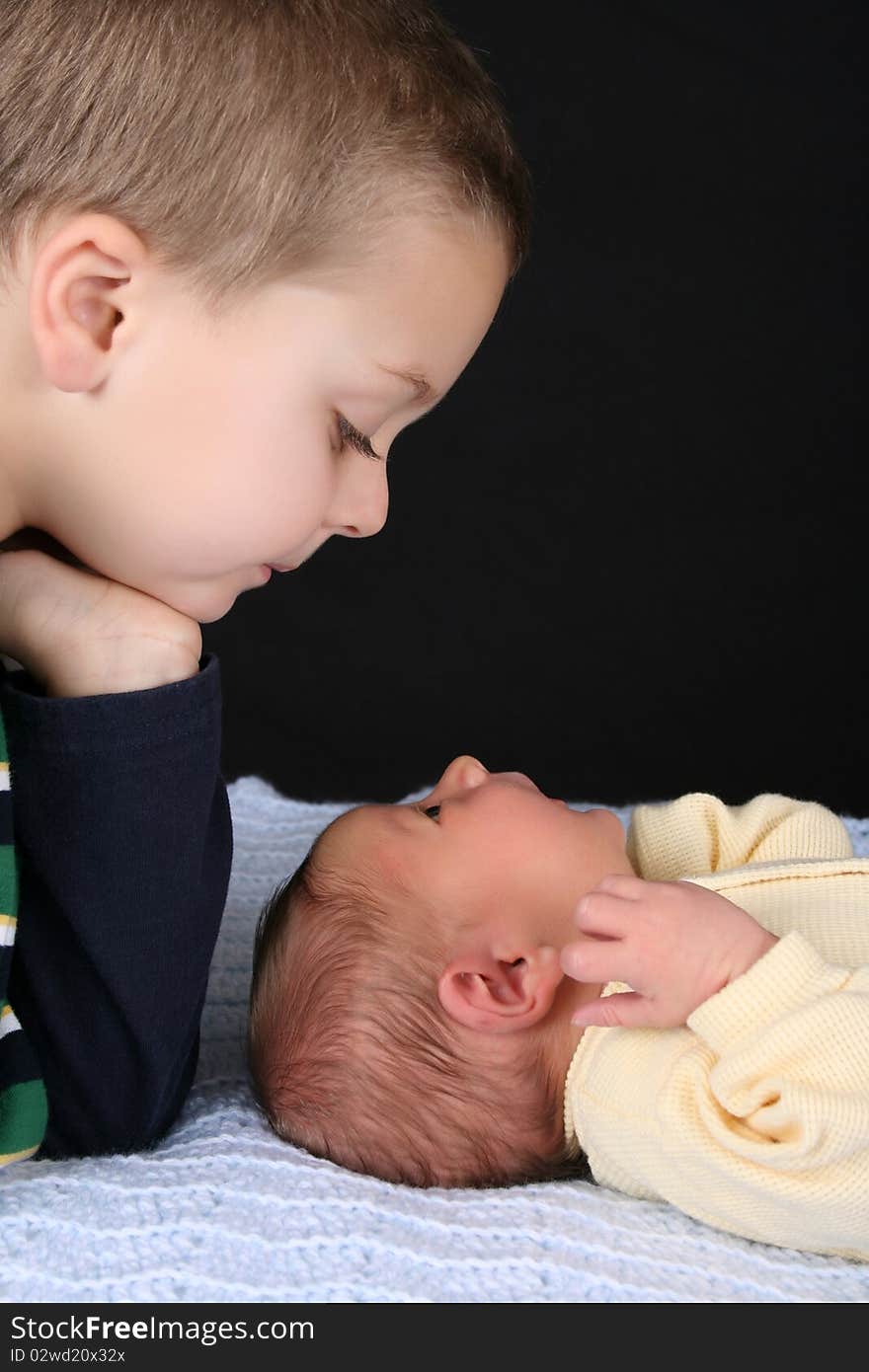 Blond boy with his newborn baby brother. Blond boy with his newborn baby brother