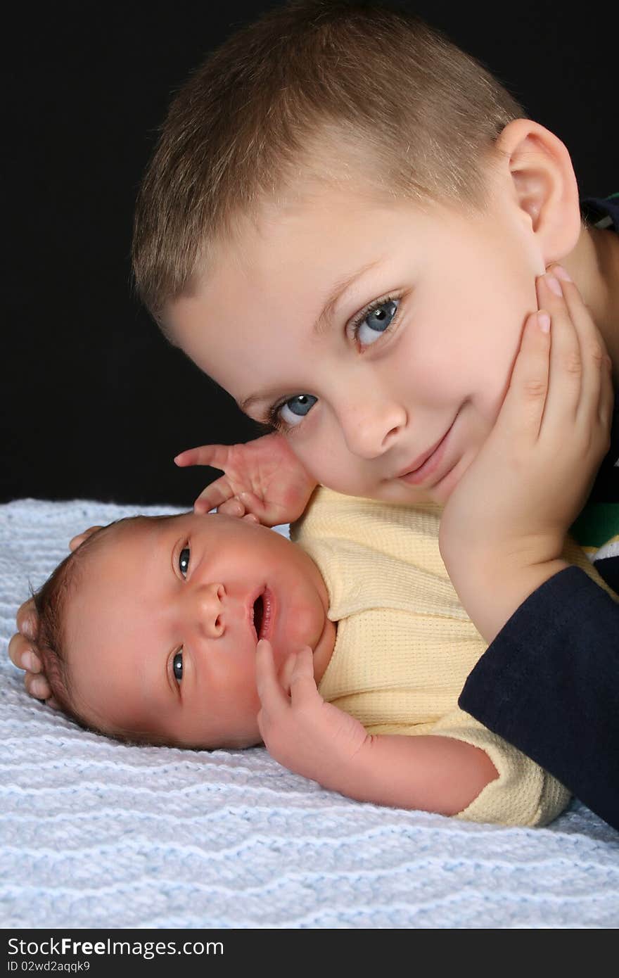 Blond boy with his newborn baby brother. Blond boy with his newborn baby brother