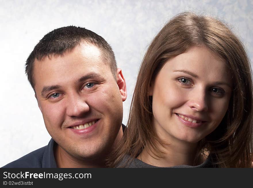 Young smiling couple over light defocused background. Young smiling couple over light defocused background