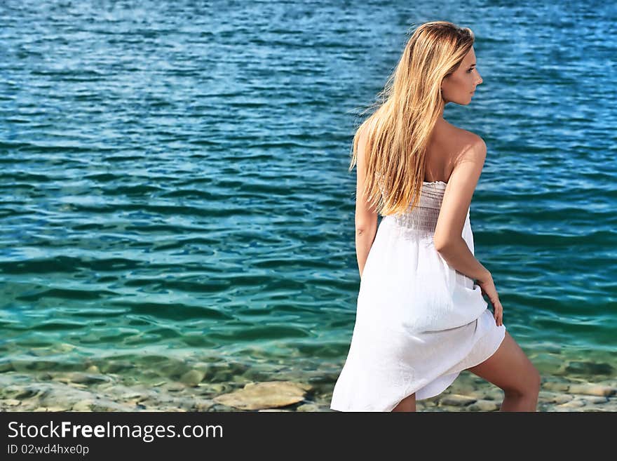 Beautiful young woman posing over sea beach. Beautiful young woman posing over sea beach.