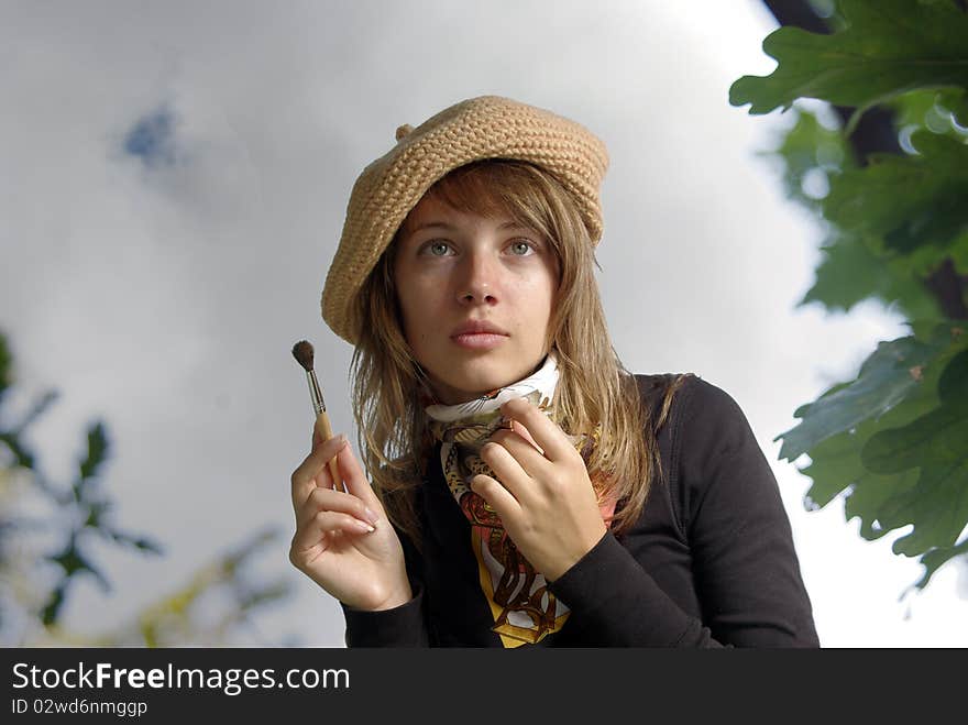 Lady artist in berret with brush.Autumn sky, dull day. Lady artist in berret with brush.Autumn sky, dull day.