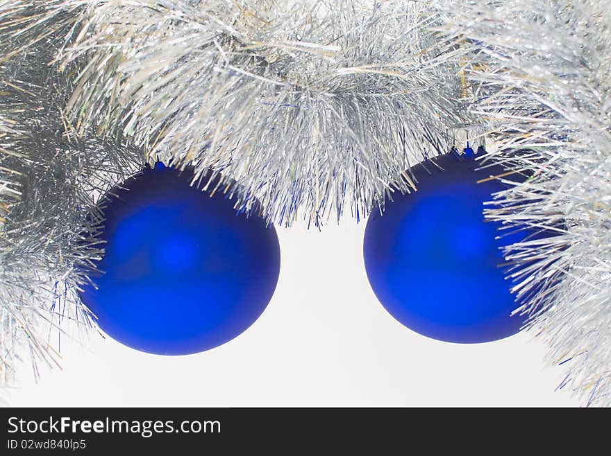 Two blue christmas ball hanging over silver christmas chain, against a white background. Two blue christmas ball hanging over silver christmas chain, against a white background