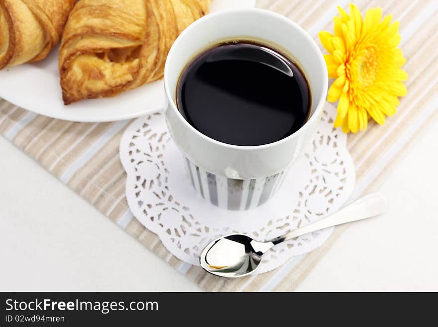 A Cup Of Black Coffee And Croissants