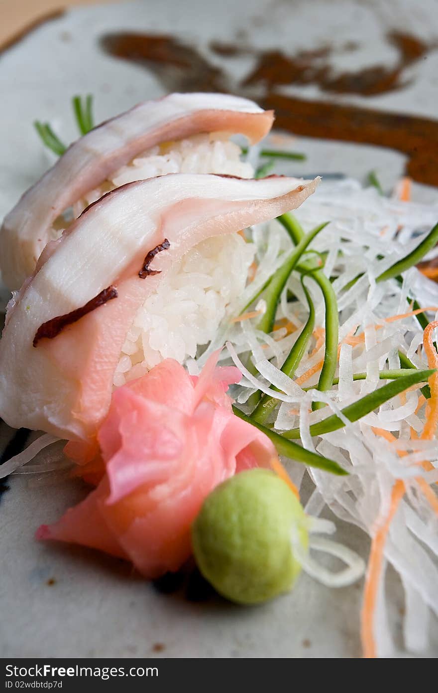 Japanese sushi with julienne cabbage, green pepper and carrot garnish served with sliced ginger and wasabi. Japanese sushi with julienne cabbage, green pepper and carrot garnish served with sliced ginger and wasabi.