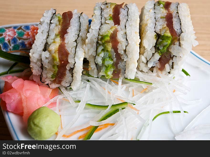 Japanese sushi served with sliced ginger and wasabi and presented on a finely decorated porcelain plate. Japanese sushi served with sliced ginger and wasabi and presented on a finely decorated porcelain plate.