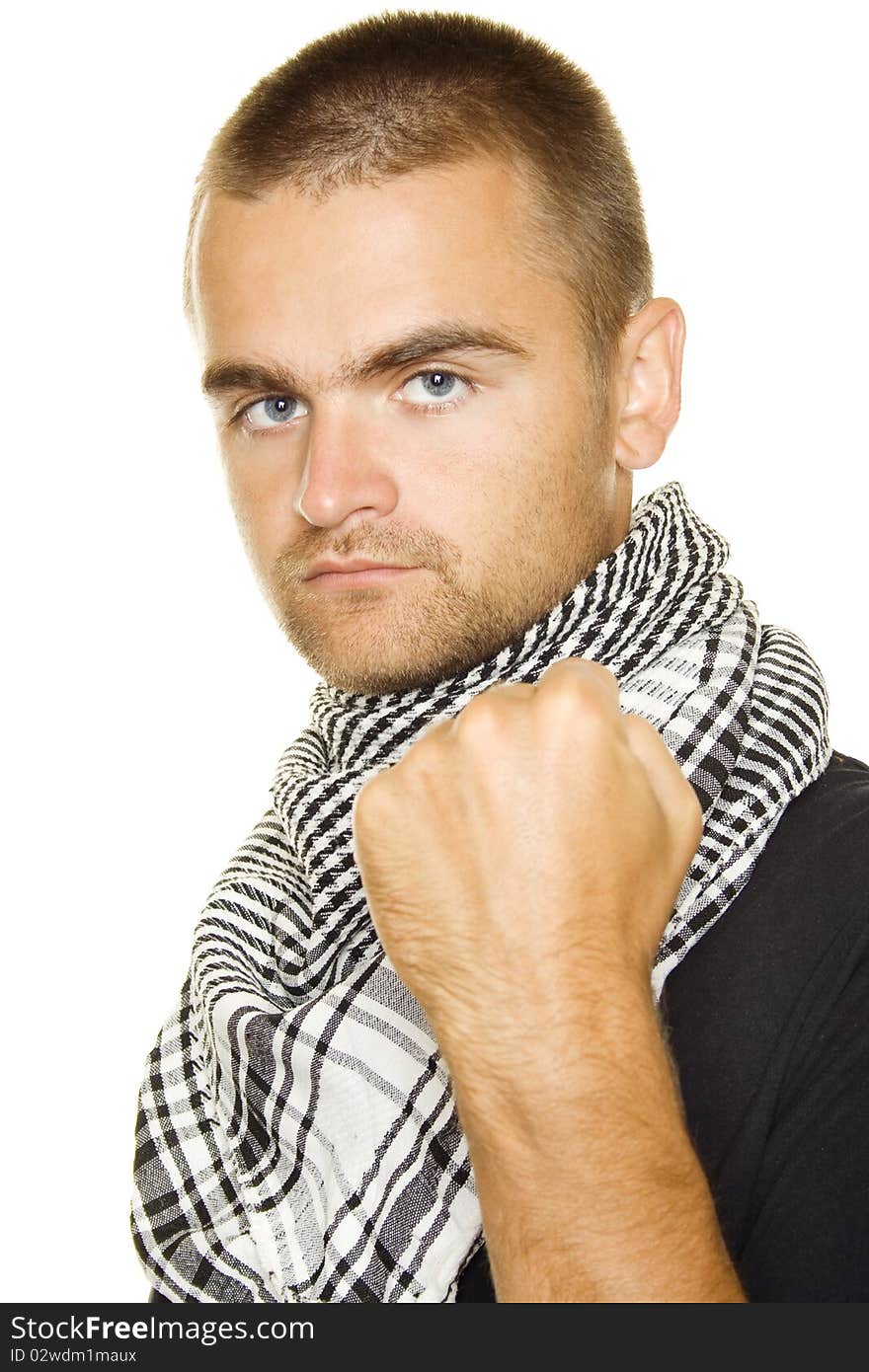 Young man dressed in black t-shirt at the neck of a Palestinian scarf. Stubble on his face. Shows a fist in the frame. Isolated on a white background. Young man dressed in black t-shirt at the neck of a Palestinian scarf. Stubble on his face. Shows a fist in the frame. Isolated on a white background