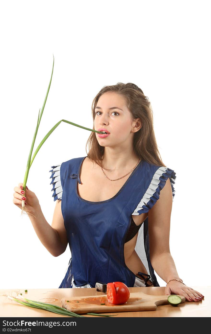 Girl in apron bit an onion. Girl in apron bit an onion