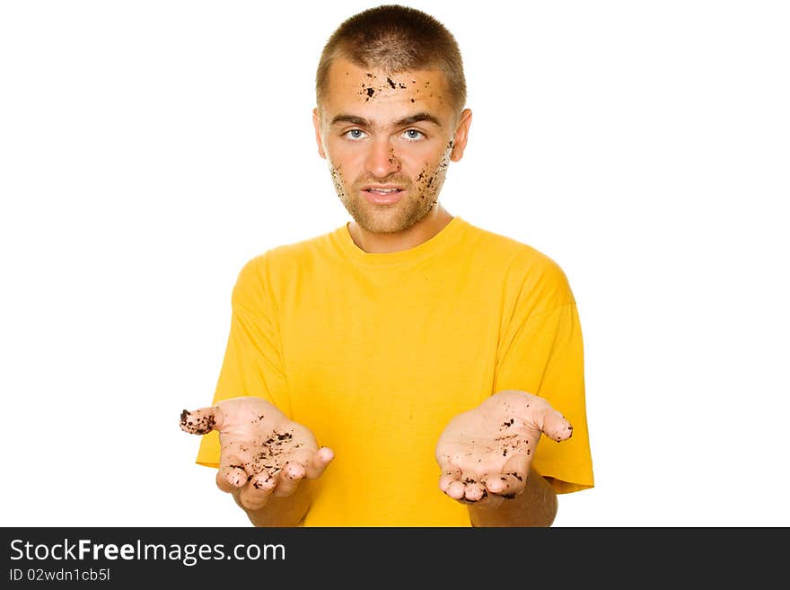 Handsome young man, his face and hands stained the ground. The guy pulls his hands to frame complaining. Isolated on a white background. Handsome young man, his face and hands stained the ground. The guy pulls his hands to frame complaining. Isolated on a white background