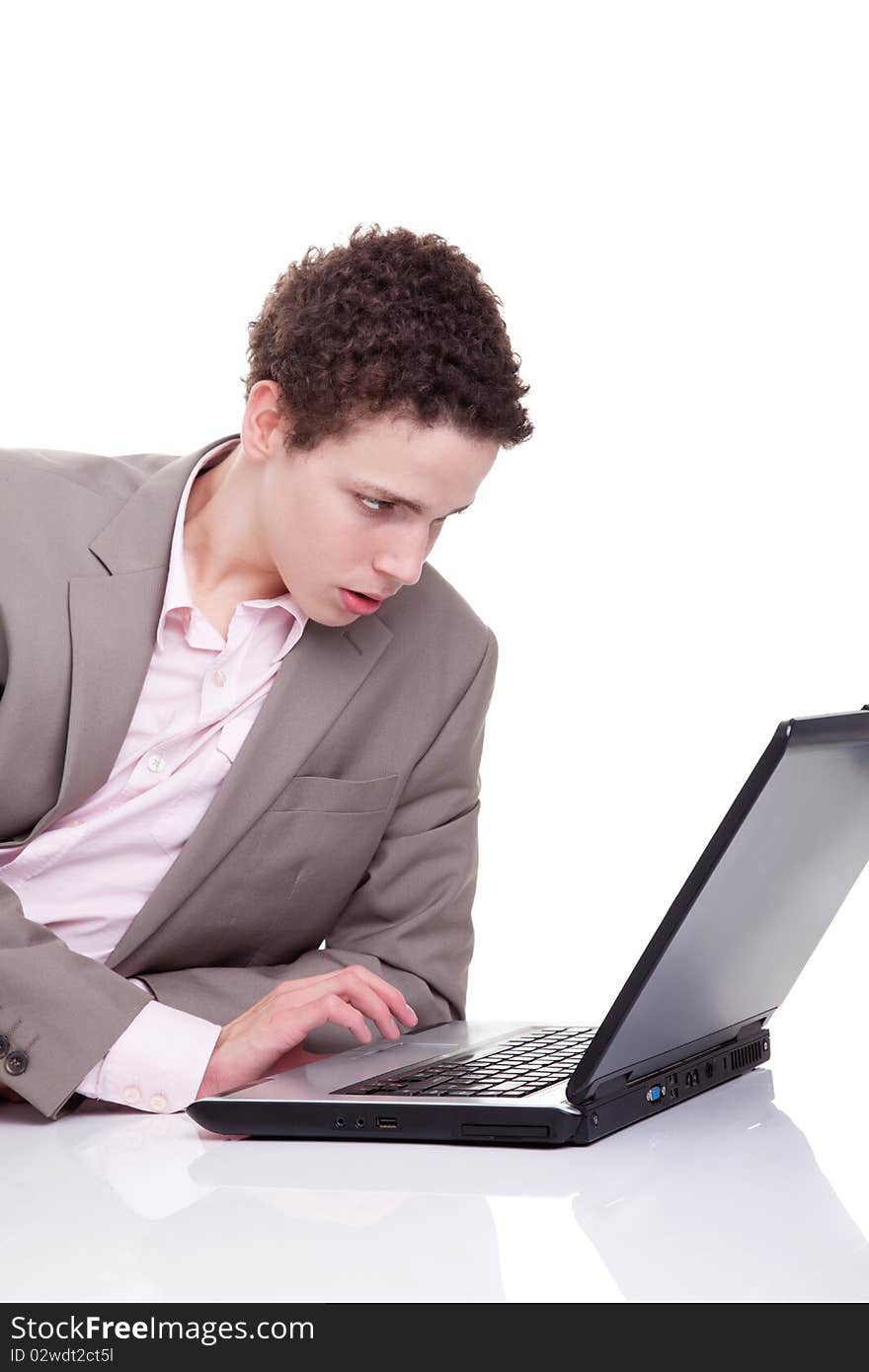 Young man typing and looking at screen of laptop, isolated on white, studio shot