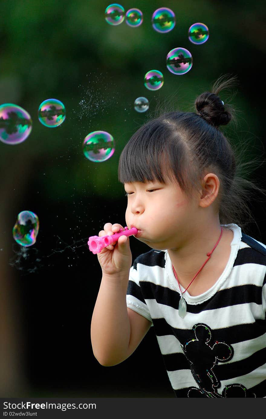 Asian child playing Blowing bubbles