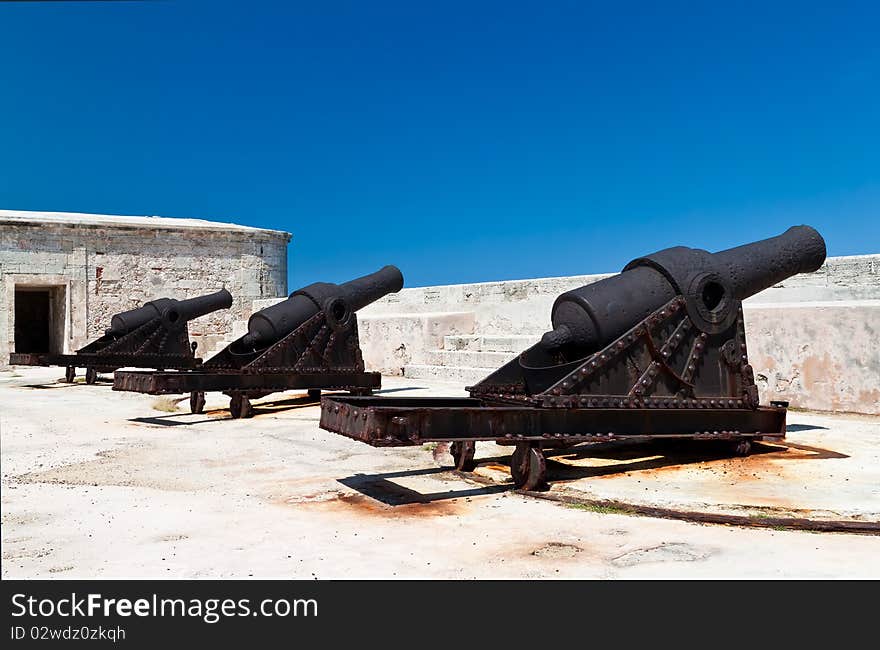 Group of ancient cannons in a stone castle on a day with a clear blue sky. Group of ancient cannons in a stone castle on a day with a clear blue sky