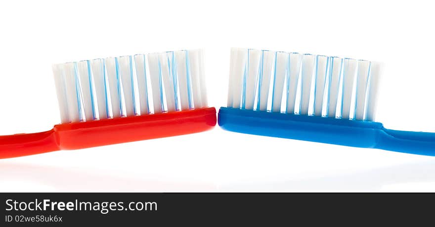 Blue and red toothbrushes on a white background