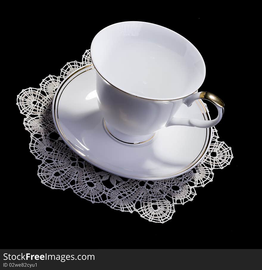 White cup on small doily with lace