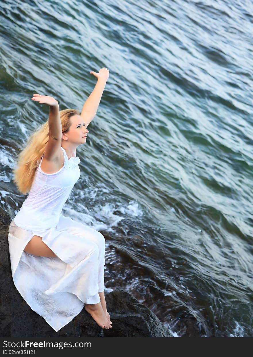 Young beautiful woman posing near the ocean. Young beautiful woman posing near the ocean