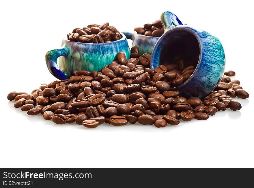 Fresh coffee beans and colorful cups on a white background. Fresh coffee beans and colorful cups on a white background