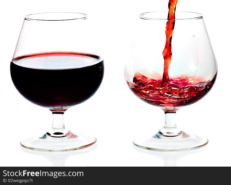 Red wine being served in transparent glasses on a white background