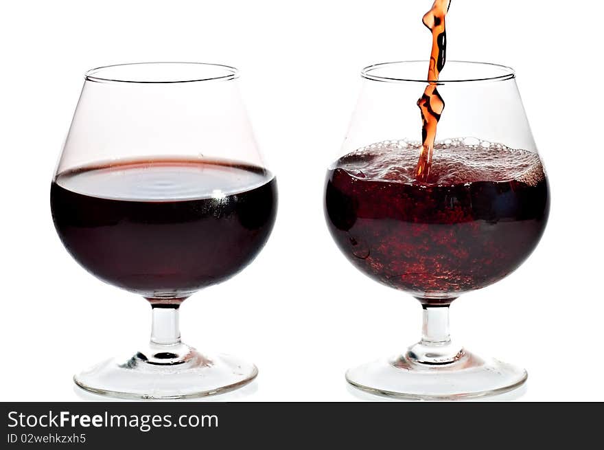 Red wine being served in transparent glasses on a white background