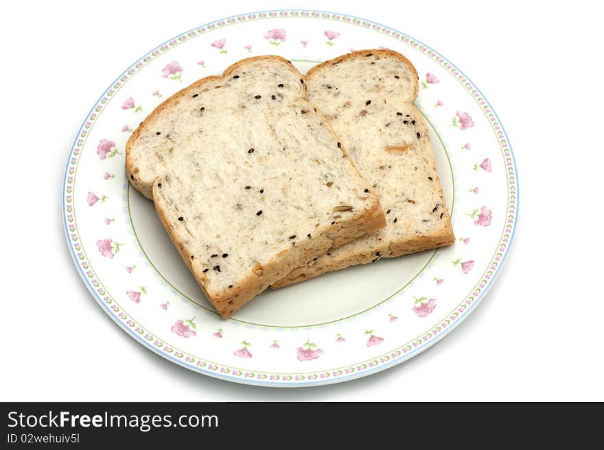 The healthy food, whole wheat for breakfast. Two piece of bread on white disk isolated on white background. The healthy food, whole wheat for breakfast. Two piece of bread on white disk isolated on white background.