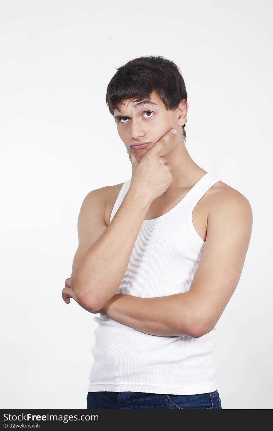 Closeup of a handsome young teenaged guy looking away in thought isolated on white