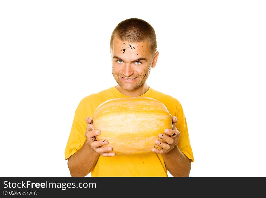 Handsome young man holding a big yellow pumpkins in their hands. An evil smile. Lots of copyspace and room for text on this isolate. Handsome young man holding a big yellow pumpkins in their hands. An evil smile. Lots of copyspace and room for text on this isolate