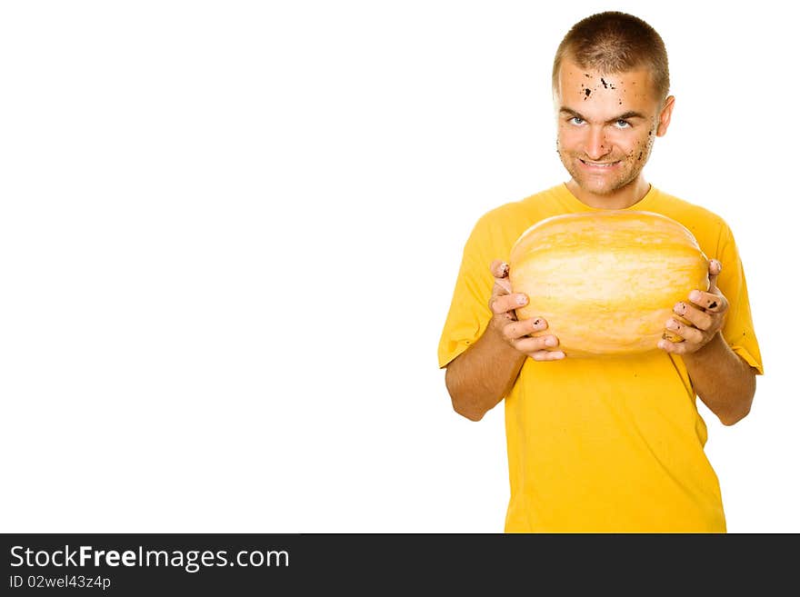 Handsome young man holding a big yellow pumpkins in their hands. An evil smile. Lots of copyspace and room for text on this isolate. Handsome young man holding a big yellow pumpkins in their hands. An evil smile. Lots of copyspace and room for text on this isolate