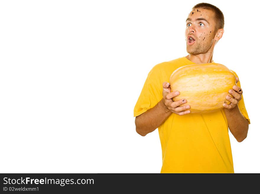 Handsome young man holding a big yellow pumpkins in their hands. Face expressed surprise, looks away. Lots of copyspace and room for text on this isolate. Handsome young man holding a big yellow pumpkins in their hands. Face expressed surprise, looks away. Lots of copyspace and room for text on this isolate