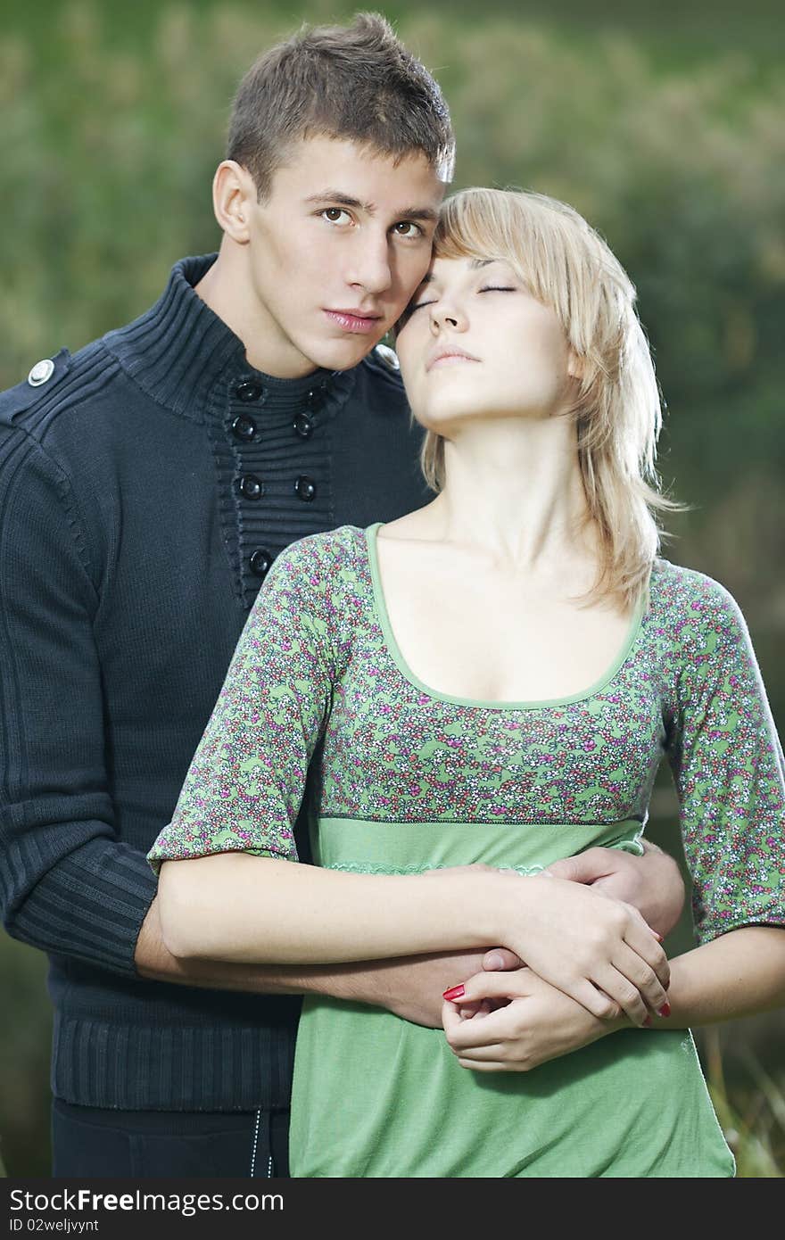 Casual beautiful young couple relaxing and cuddling in the park. Casual beautiful young couple relaxing and cuddling in the park