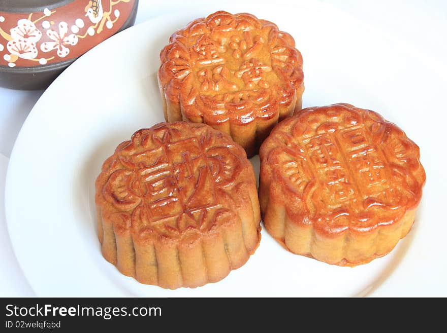 Moon cakes with Chinese teapot on white background. Consumed during Chinese mid-autumn festival. Moon cakes with Chinese teapot on white background. Consumed during Chinese mid-autumn festival