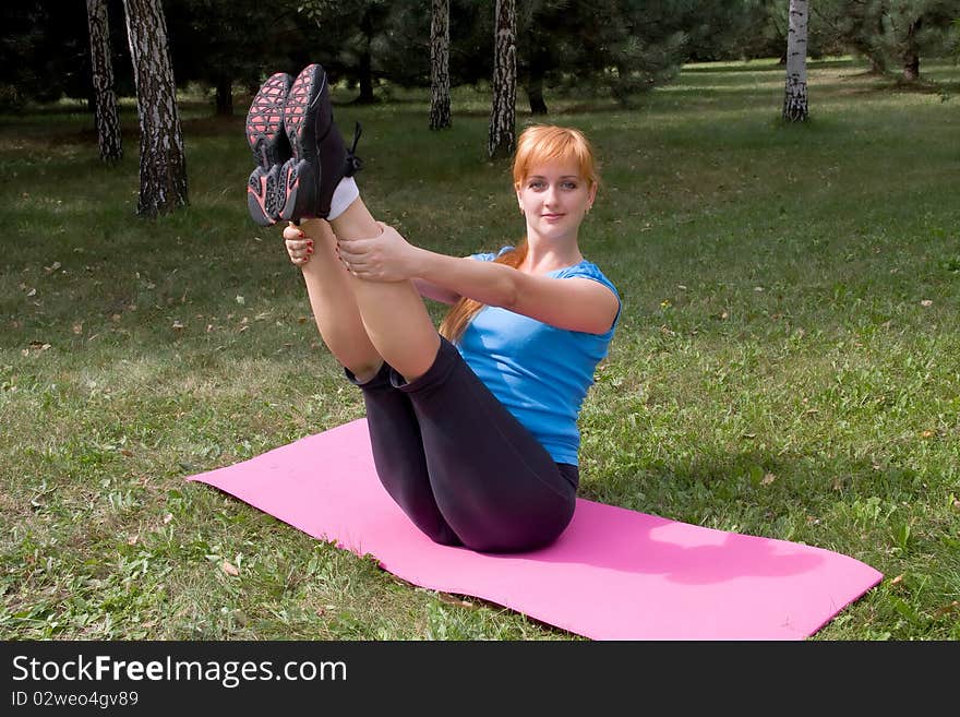 Woman engages in yoga, sits on buttocks in splits. Woman engages in yoga, sits on buttocks in splits