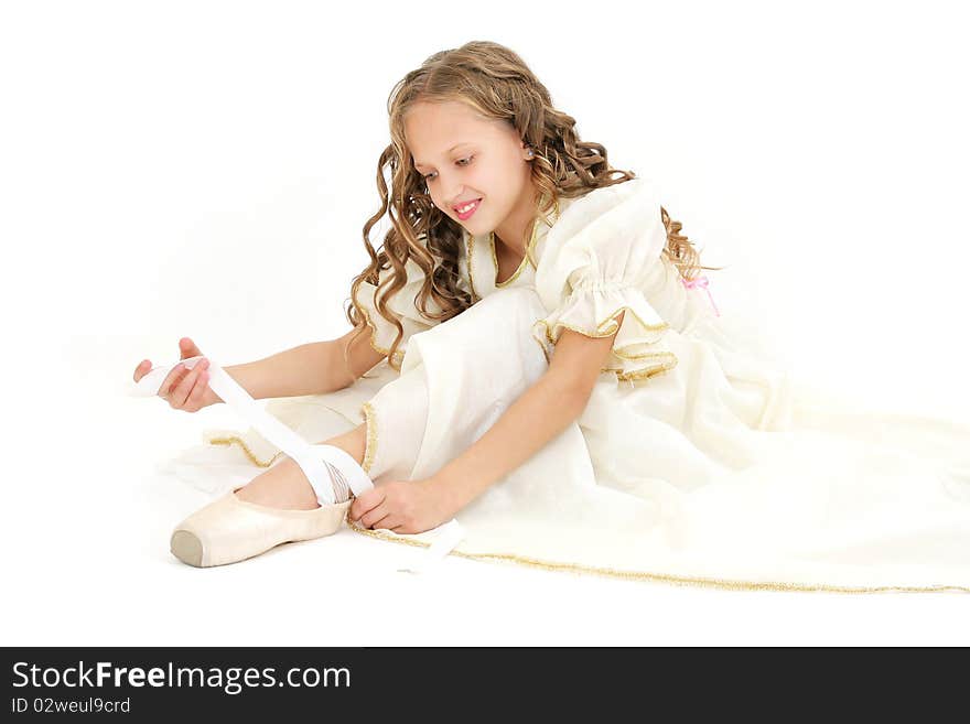 Beautiful teenage girl tying her pointes studio shot on white. Beautiful teenage girl tying her pointes studio shot on white