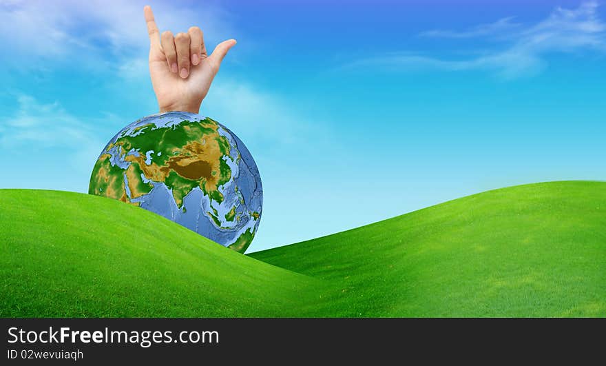 A Hand With A Globe And A Grass Field