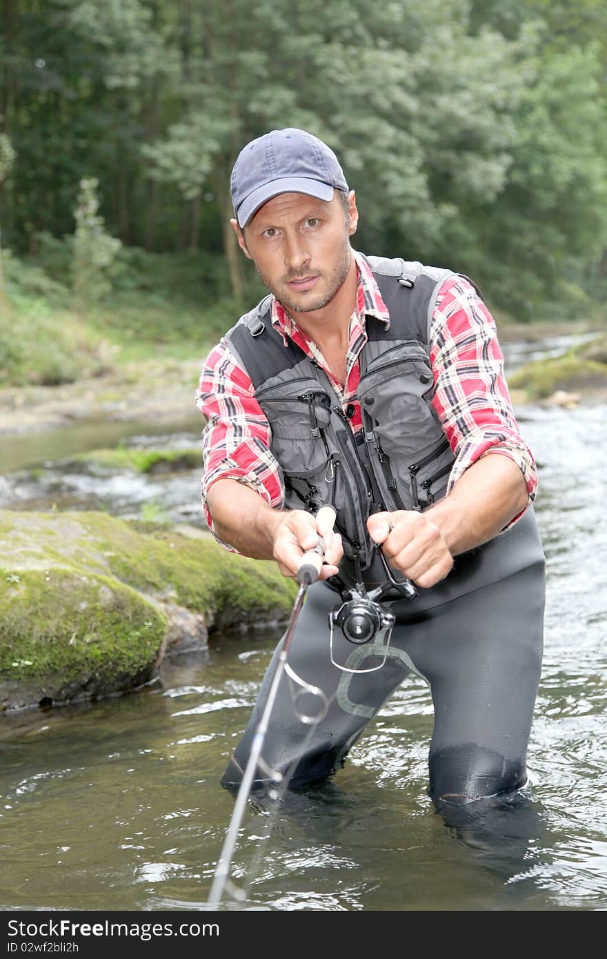 Fisherman in river with fishing rod. Fisherman in river with fishing rod