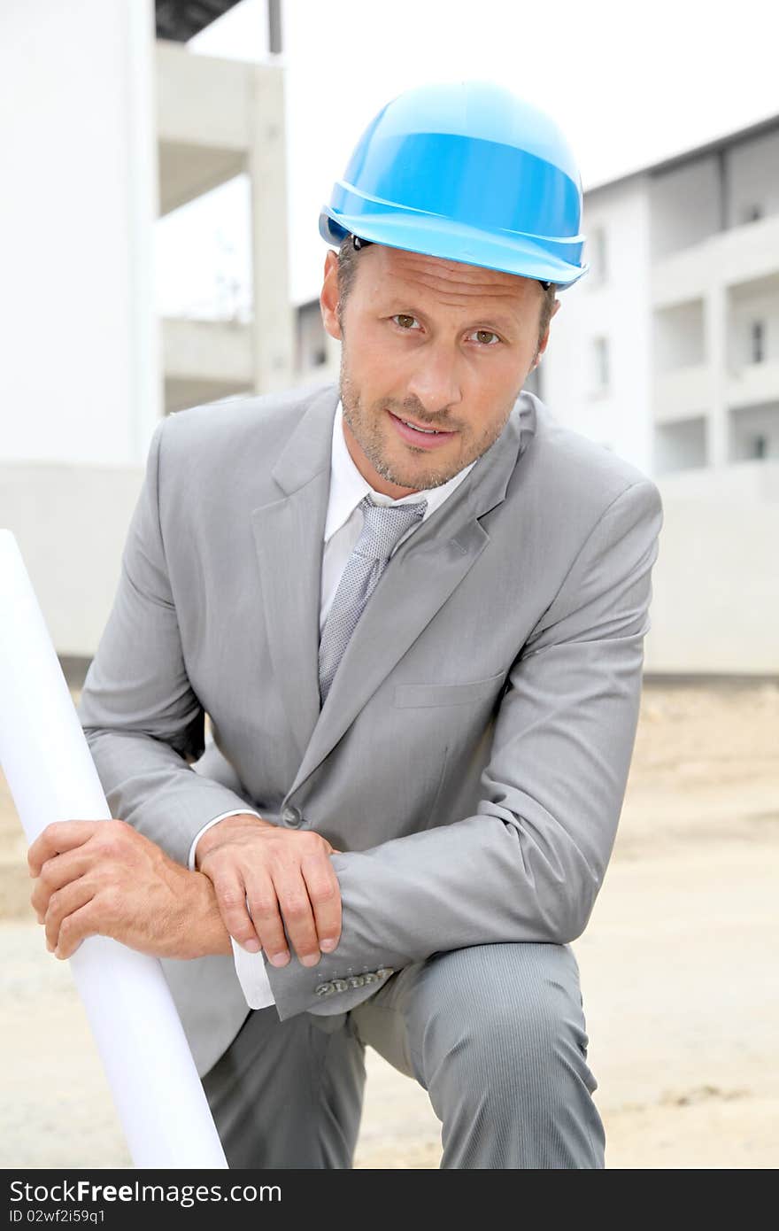 Businessman with helmet checking site under construction. Businessman with helmet checking site under construction