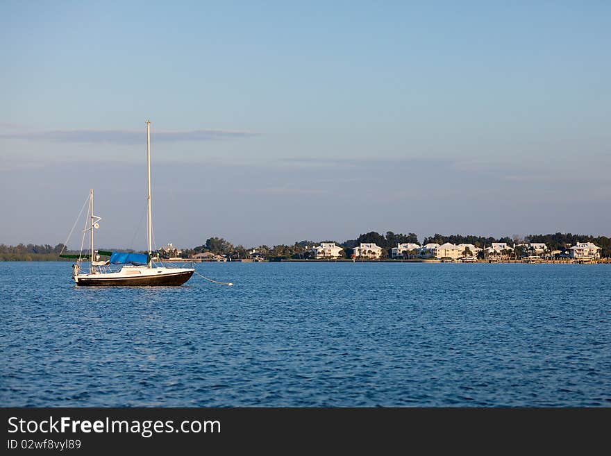 Sailboat on the water with home in the background