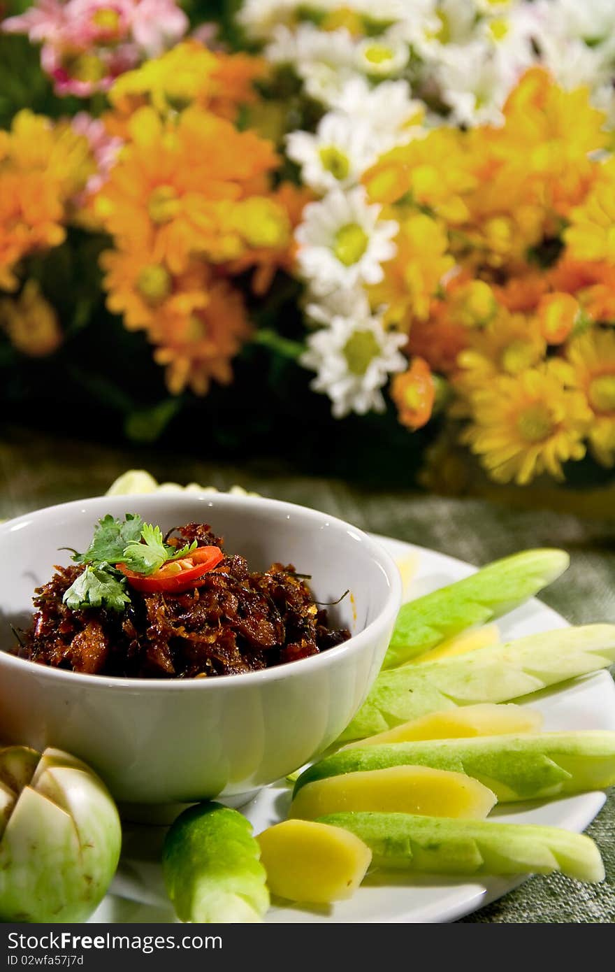 A tom yum sauce of shrimp paste and chili cuisine and vegetables with flower background