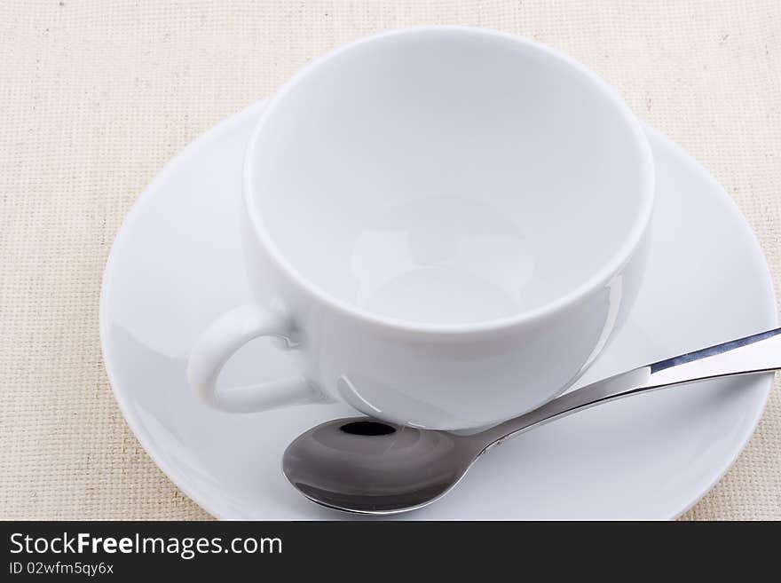 Empty ceramic cup with a saucer on a white background.